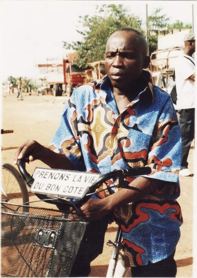 Ancienne photo de Michel Gohou avec son vélo et une phrase de motivation 