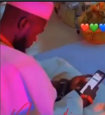 En pleine cérémonie de mariage, un jeune marié surprise entrain de faire un des paries sportifs en ligne sur son téléphone.