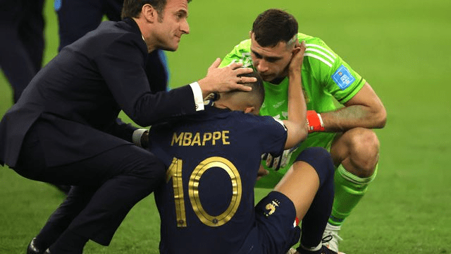 Emiliano Martinez réconfortant Kylian Mbappé près du président Français Emmanuel Macron 
