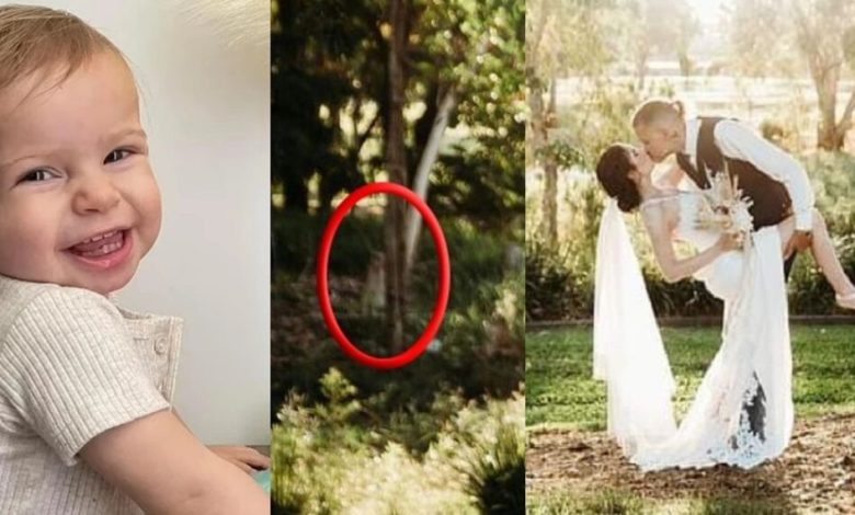 Sur une photo du couple partageant un baiser le jour de leur mariage, on peut voir une silhouette sombre se cacher derrière un arbre en arrière-plan.